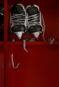 Pair of hockey skates on the shelf in a locker room.  Copy space.Click on an