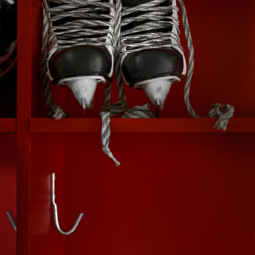 Pair of hockey skates on the shelf in a locker room.  Copy space.Click on an